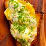 Breakfast toast with jammy egg mix on a wooden board