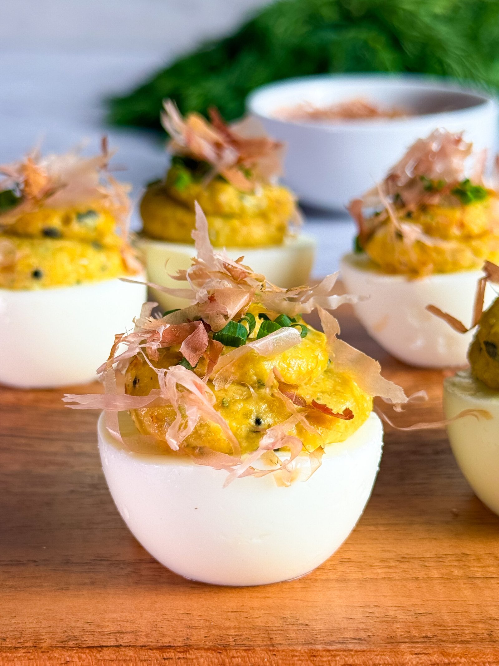 Four egg whites, filled with the yolk mix and topped with chopped chives and bonito flakes. Served on a wooden board