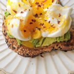 Multigrain toast, topped with avocado, 2 boiled eggs , red pepper flakes and honey