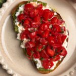 Toast with tomatoes and pesto on a round plate