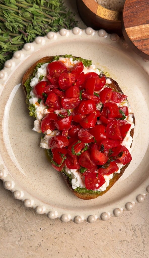 Toast with tomatoes and pesto on a round plate