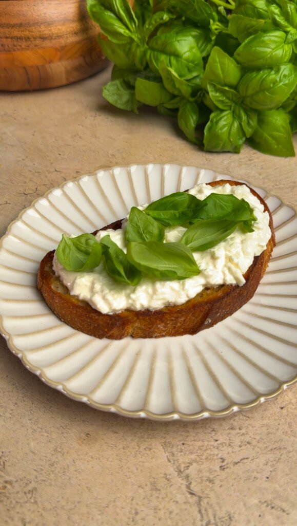 Toast with cheese and basil on a round plate