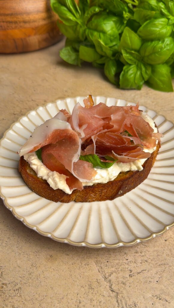 Toast with prosciutto on a round plate
