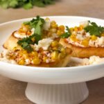 Mexican Street Corn Ricotta Tartines on a white cake stand