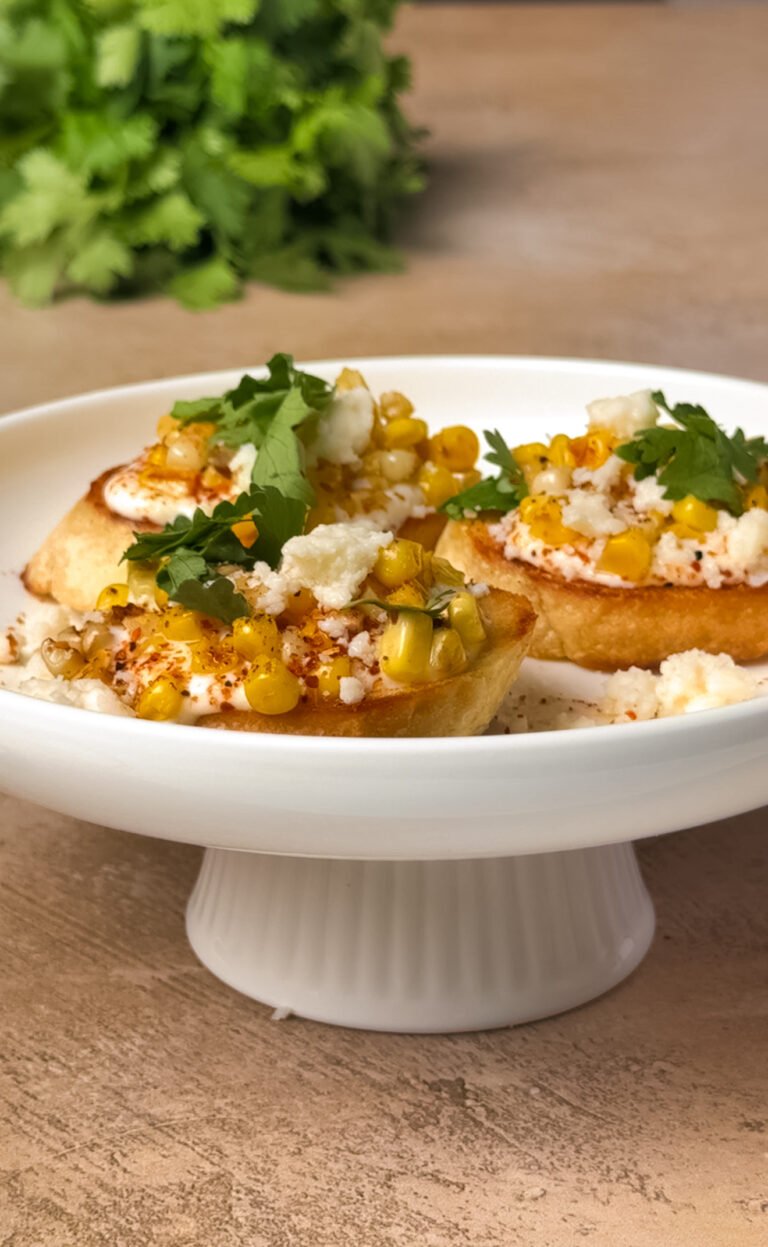 Mexican Street Corn Ricotta Tartines on a white cake stand