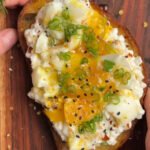 Hands are holding Breakfast toast with cottage cheese and egg. Wooden board on a background
