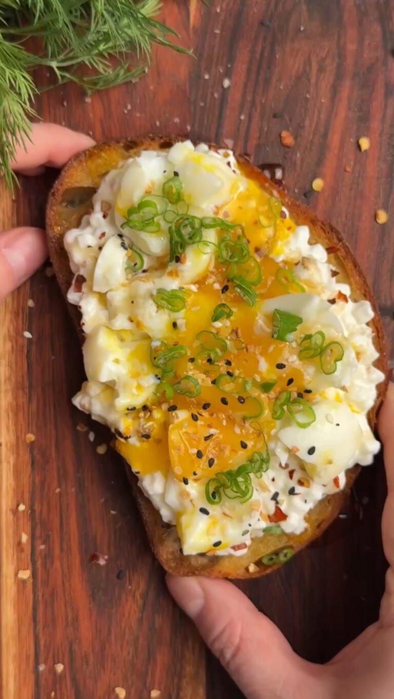 Hands are holding Breakfast toast with cottage cheese and egg. Wooden board on a background