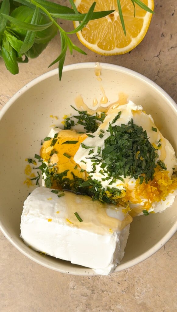 Mixing goat cheese, cream cheese, lemon zest, and tarragon for a layered appetizer base