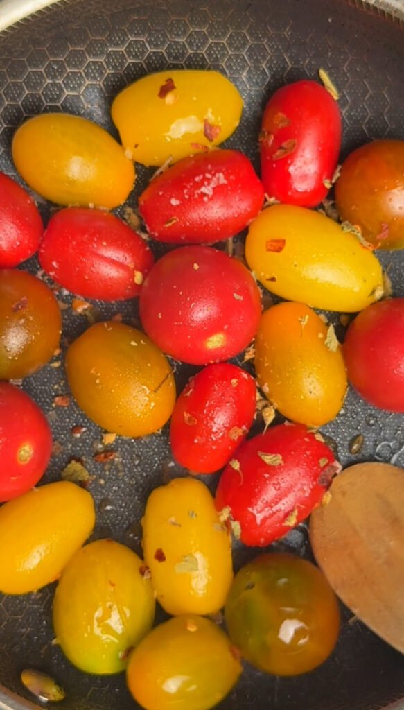 cherry tomatoes with olive oil and red pepper flakes in skillet