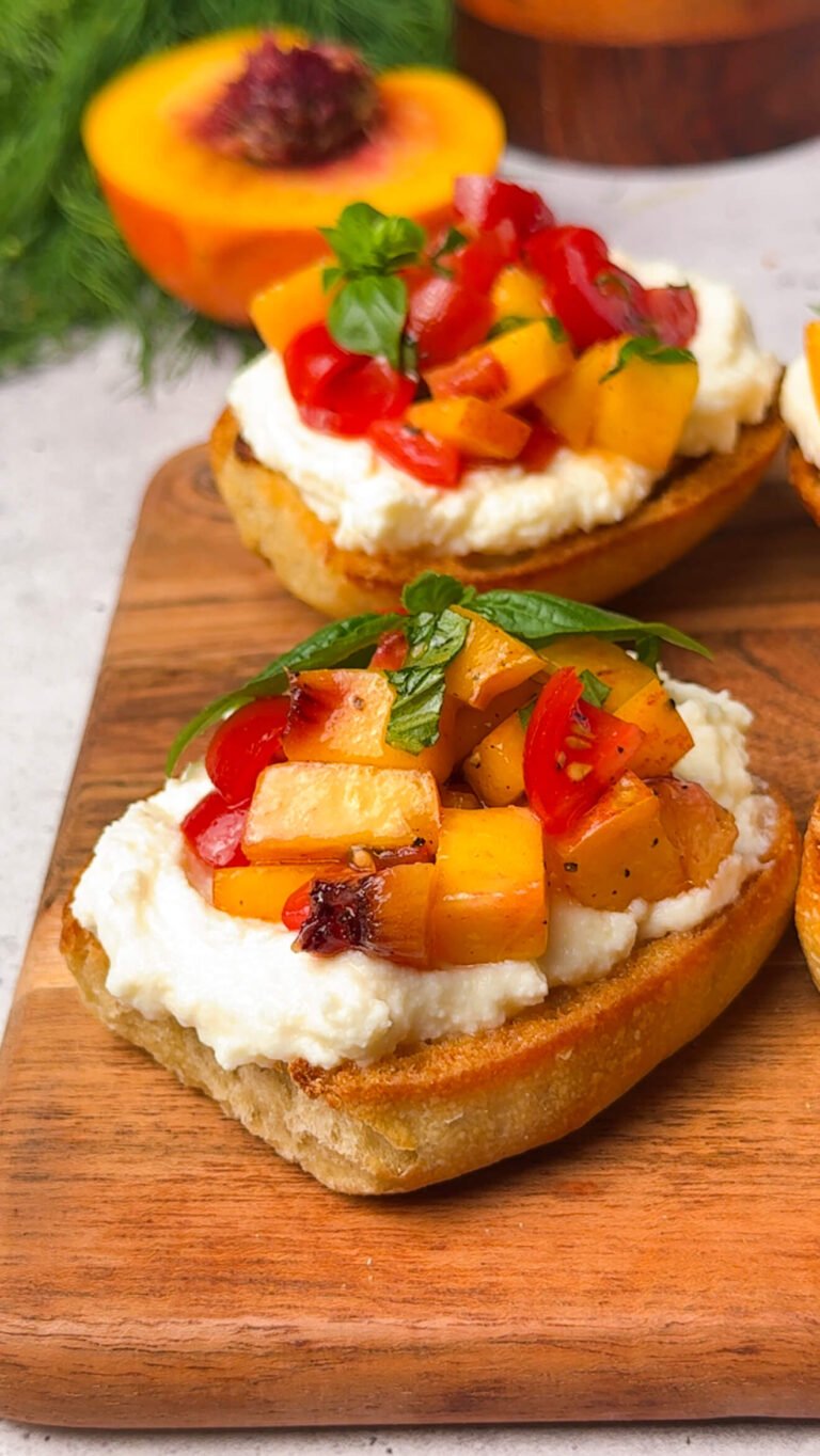Peach bruschetta topped with juicy peaches, cherry tomatoes, and basil on creamy ricotta spread over golden sourdough toast, drizzled with honey