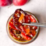 Homemade sun-dried tomato with garlic slice lifted from a jar of preserved tomatoes, plums, and olive oil