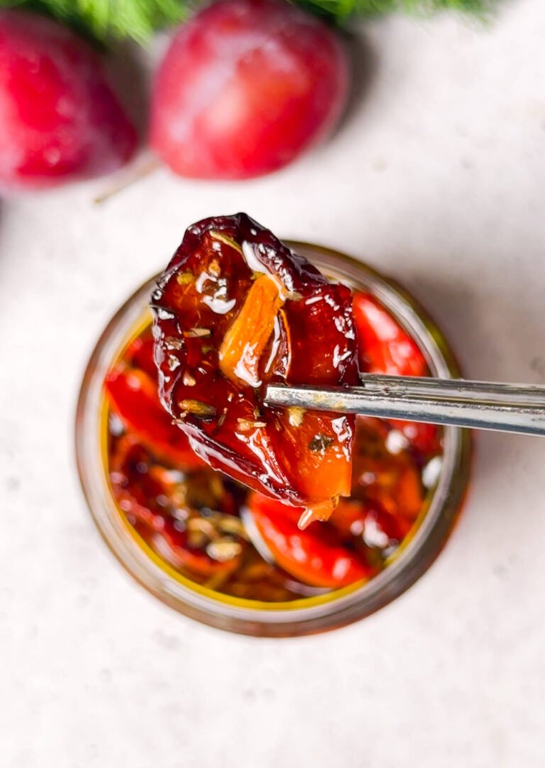 Homemade sun-dried tomato with garlic slice lifted from a jar of preserved tomatoes, plums, and olive oil