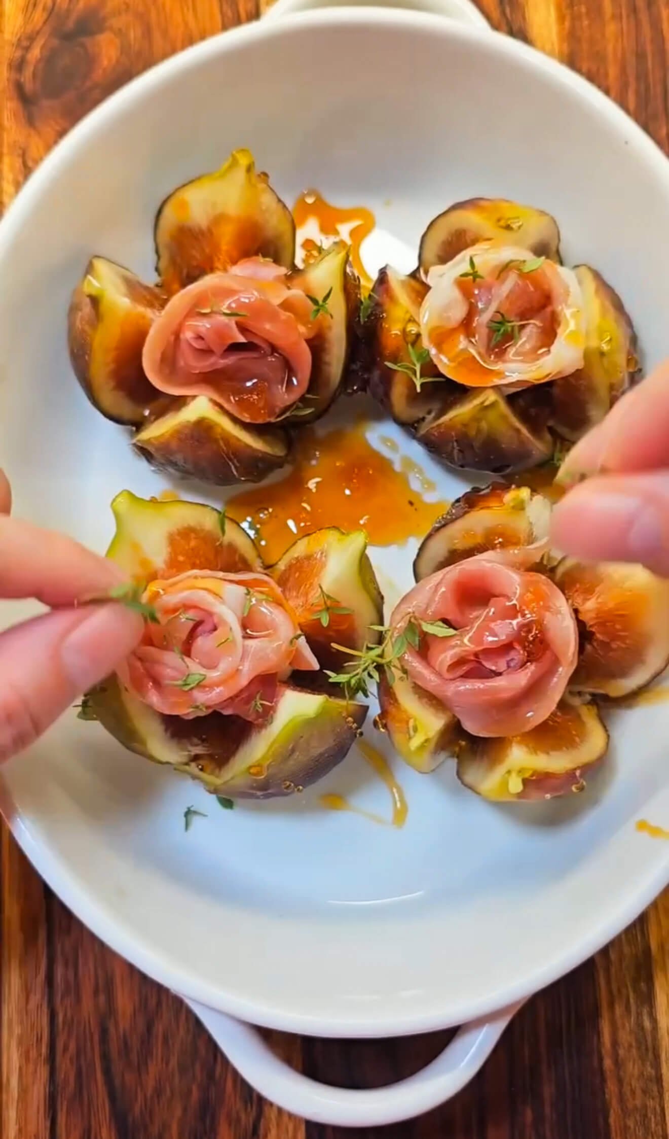 Baked figs stuffed with goat cheese and topped with prosciutto rosettes, drizzled with maple syrup and sprinkled with fresh thyme.