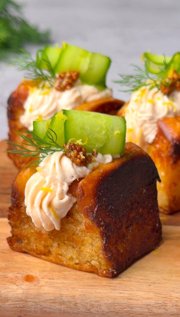 Brunch rolls with smoked salmon mousse, cucumber ribbon, dill, and whole grain mustard on a wooden board.
