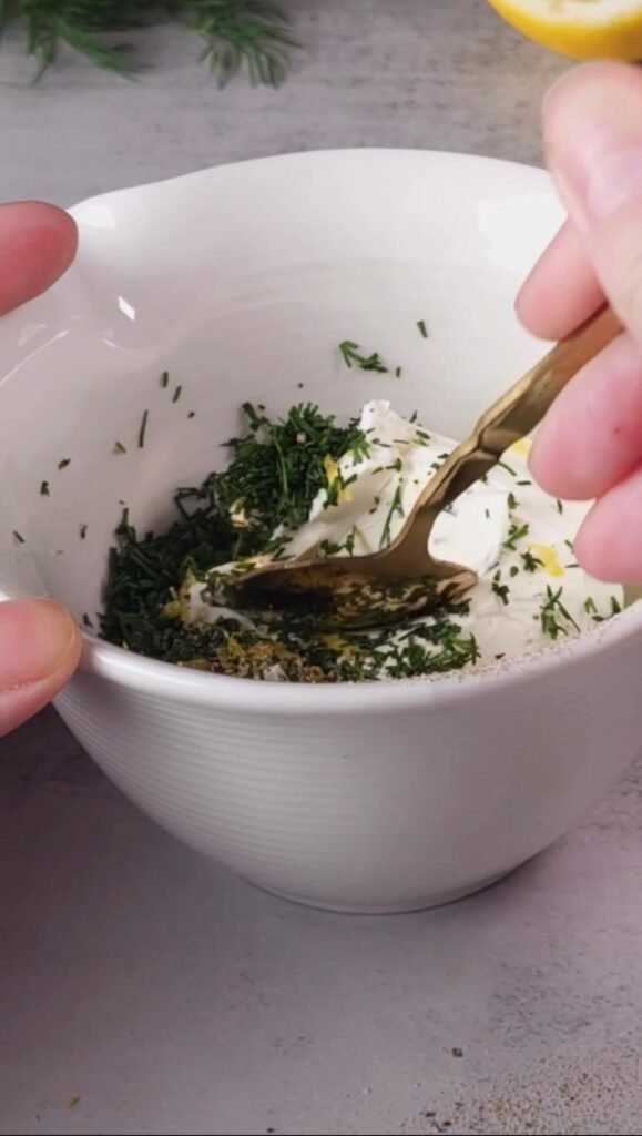 Whipped cream cheese mixed with fresh dill, lemon zest, olive oil, salt, and pepper for smoked salmon appetizers