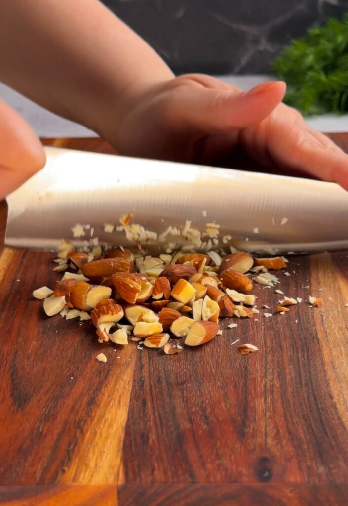 Toasted almonds being chopped for added crunch in a Million Dollar cheese stack