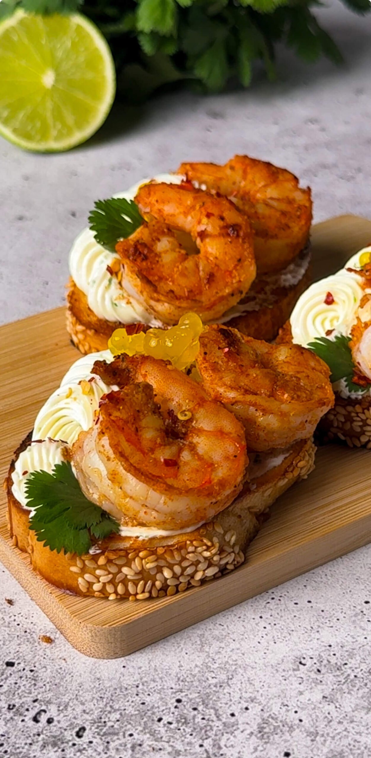 Shrimp crostini appetizer with seasoned shrimp, piped citrus cream cheese, and fresh cilantro