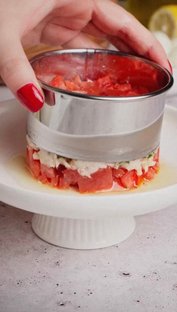 Assembling layered Italian tuna tomato mozzarella salad using a food ring