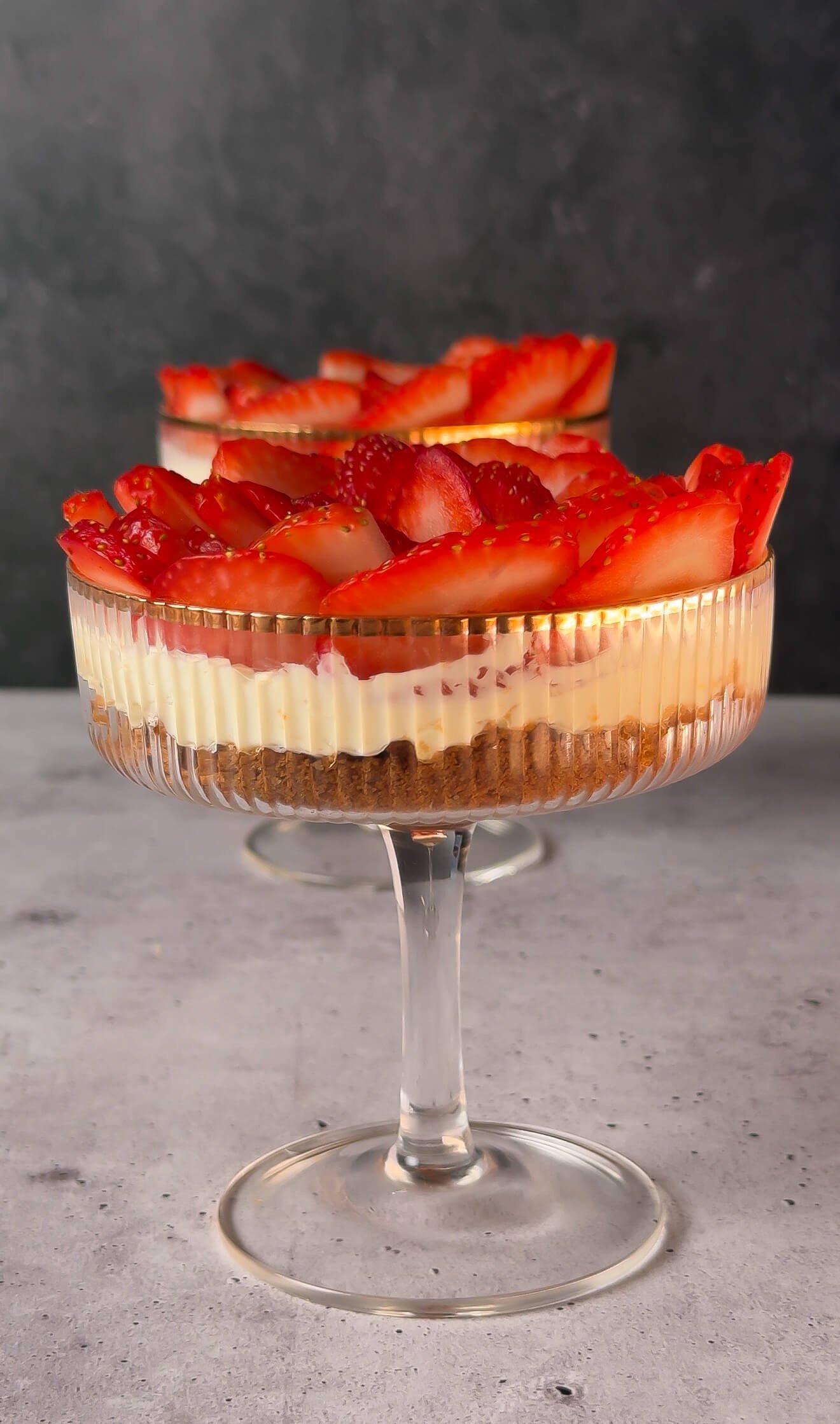 Finished strawberry mascarpone parfaits layered with mascarpone cream, cookie crumbs, and fresh strawberries