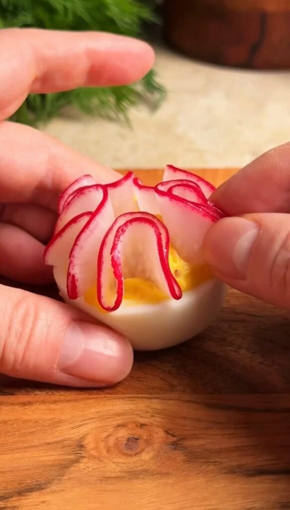 placing radish petals on deviled egg to create flower decoration