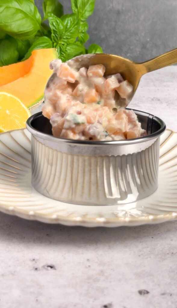 Close-up of creamy melon prosciutto tartare showing diced melon, prosciutto, and mascarpone texture