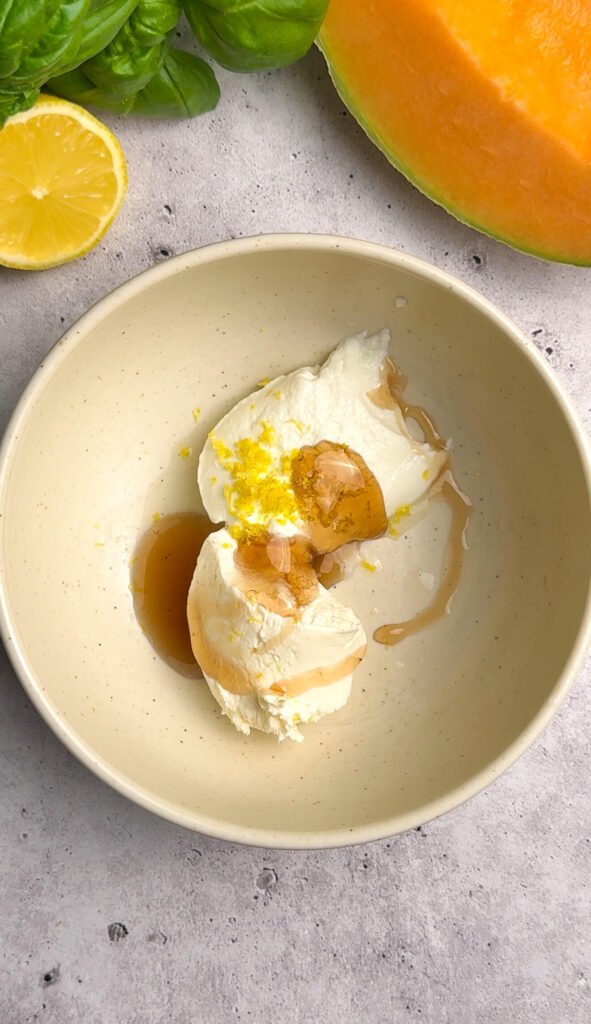 Mascarpone cream with honey, lemon zest, and lemon juice in a bowl for melon prosciutto tartare