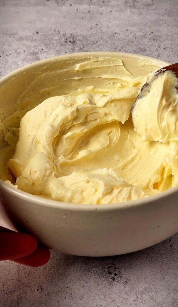 Smooth and fluffy orange-scented mascarpone cream mixed for a strawberry dessert