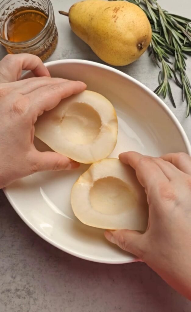 Fresh pear halves with centers scooped out, ready to make baked pear with goat cheese and honey