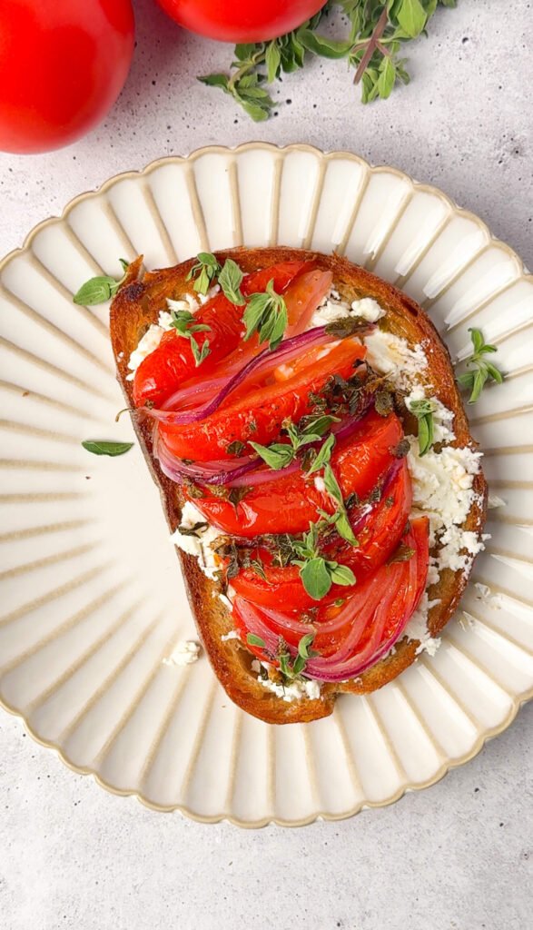 Roasted tomato and feta toast topped with slow-roasted tomatoes, red onion, and oregano