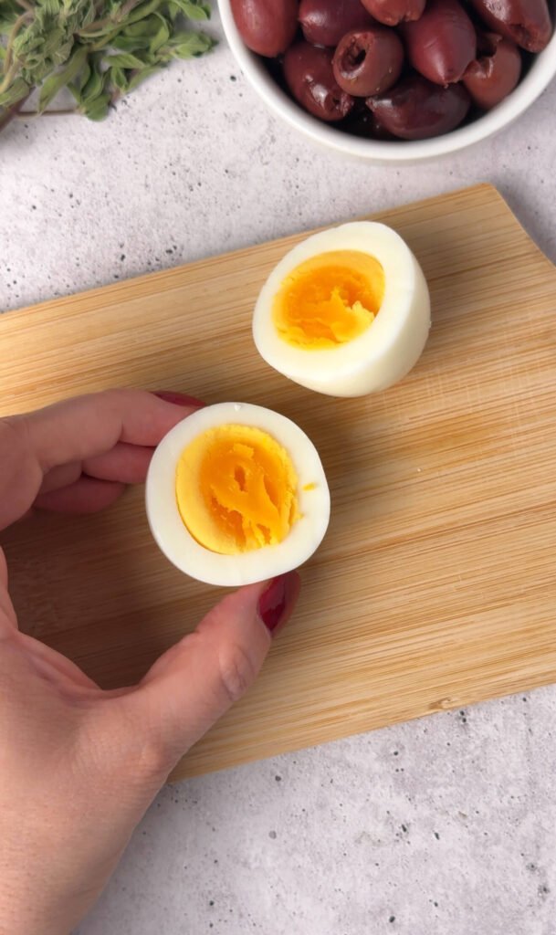 Hard boiled eggs cut in half with creamy yolks, preparing Mediterranean deviled eggs recipe