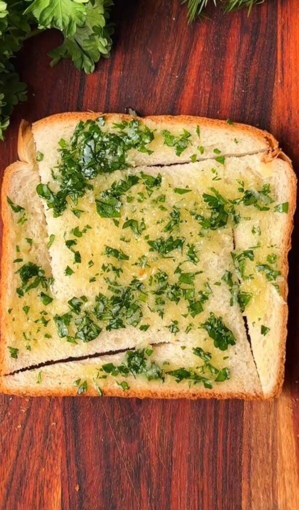 Soft bread sliced into windmill shape and spread with garlic butter and fresh parsley before baking