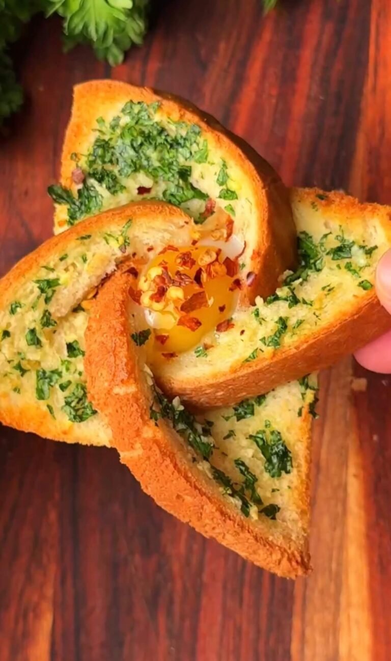 Garlic toast with quail egg in windmill shape, crispy golden edges and soft center topped with parsley and red pepper flakes