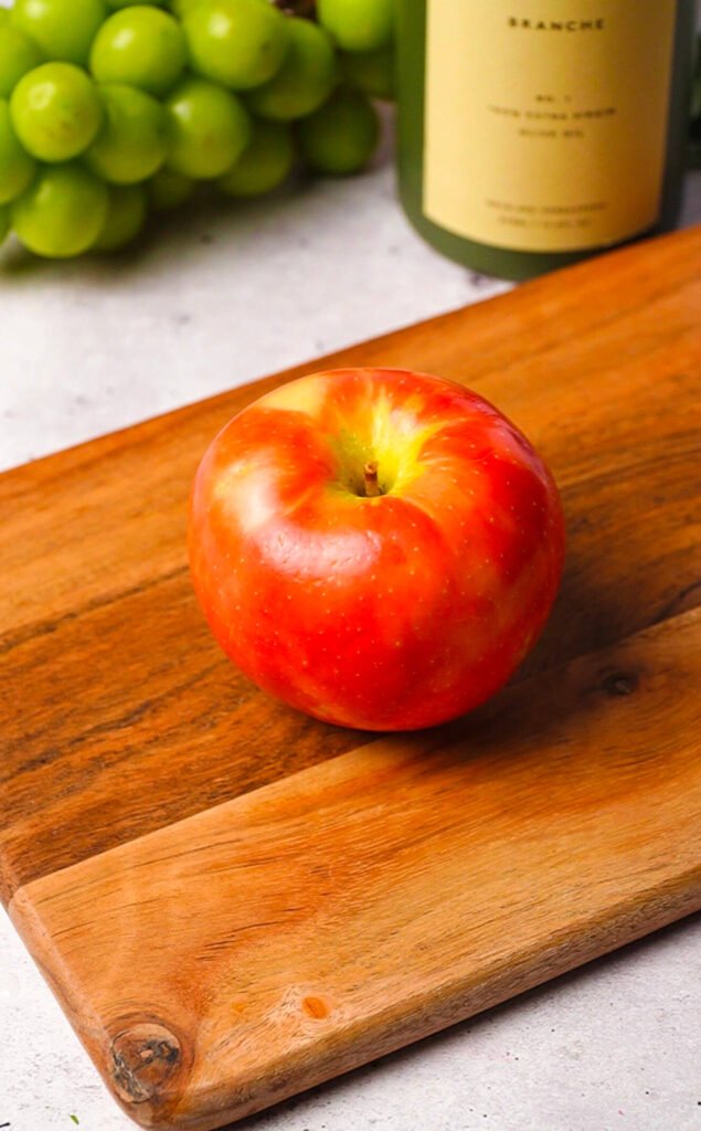 fresh honeycrisp apple on wooden board for waldorf salad with burrata