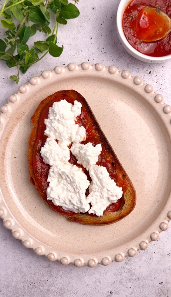 pizza toast with marinara and cottage cheese layered on crispy sourdough