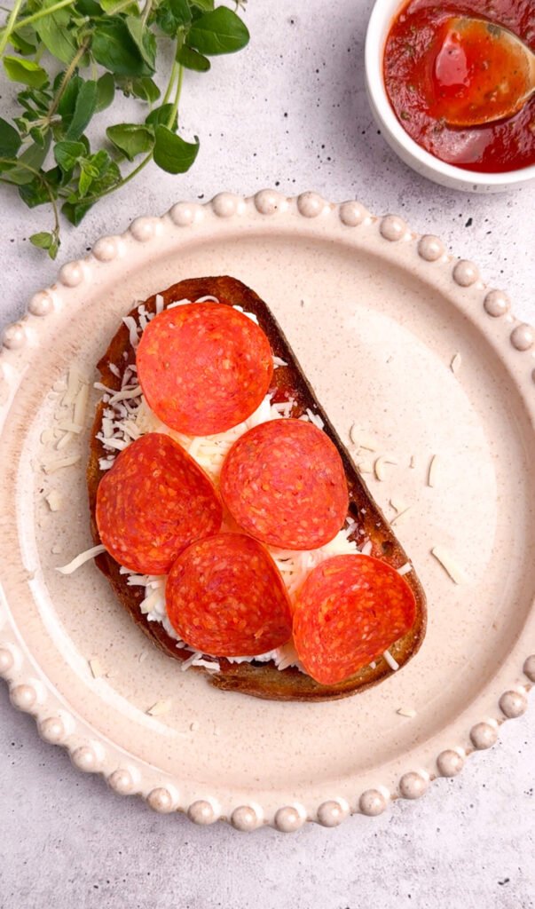pizza toast topped with mozzarella and pepperoni slices before air frying