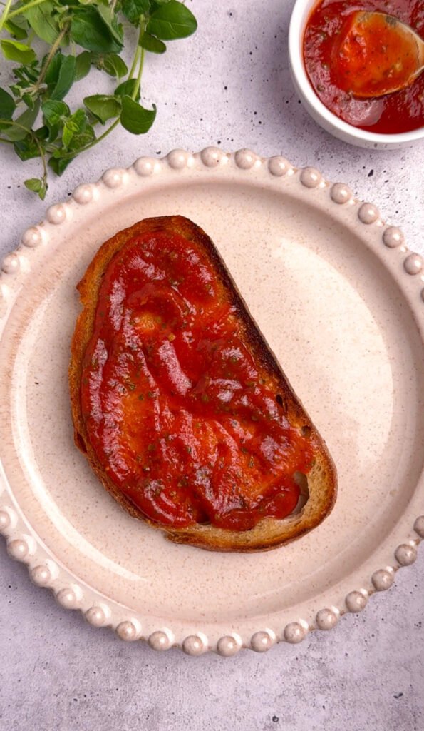 pizza toast sourdough with marinara sauce spread evenly on toasted bread