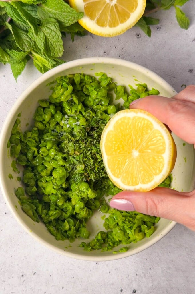 mashing peas with lemon juice and mint for ricotta pea timbale filling