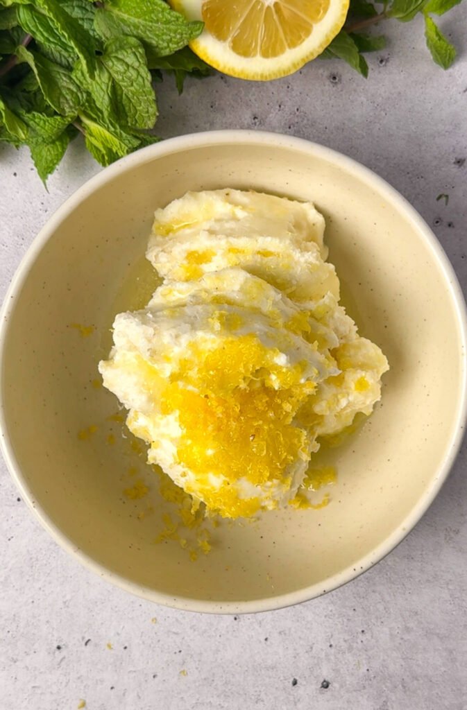 ricotta mixture with lemon zest for ricotta pea timbale in bowl with fresh mint and lemon