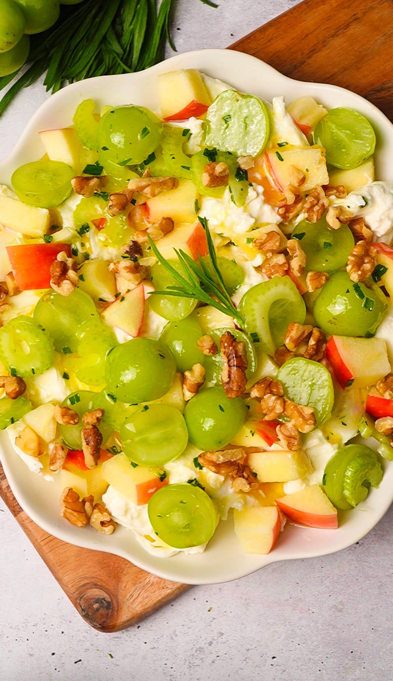 waldorf salad with burrata, apples, grapes, celery and toasted walnuts on a serving plate