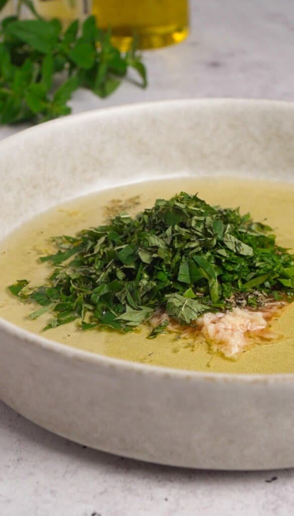 Herb and garlic marinade with olive oil, red wine vinegar, fresh parsley and oregano in a white ceramic bowl
