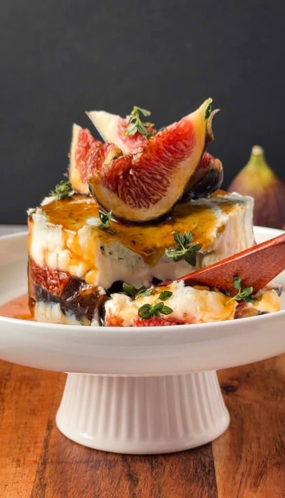 Cross-section of a gorgonzola fig and honey stack showing layered cheese and figs, served with a spoon