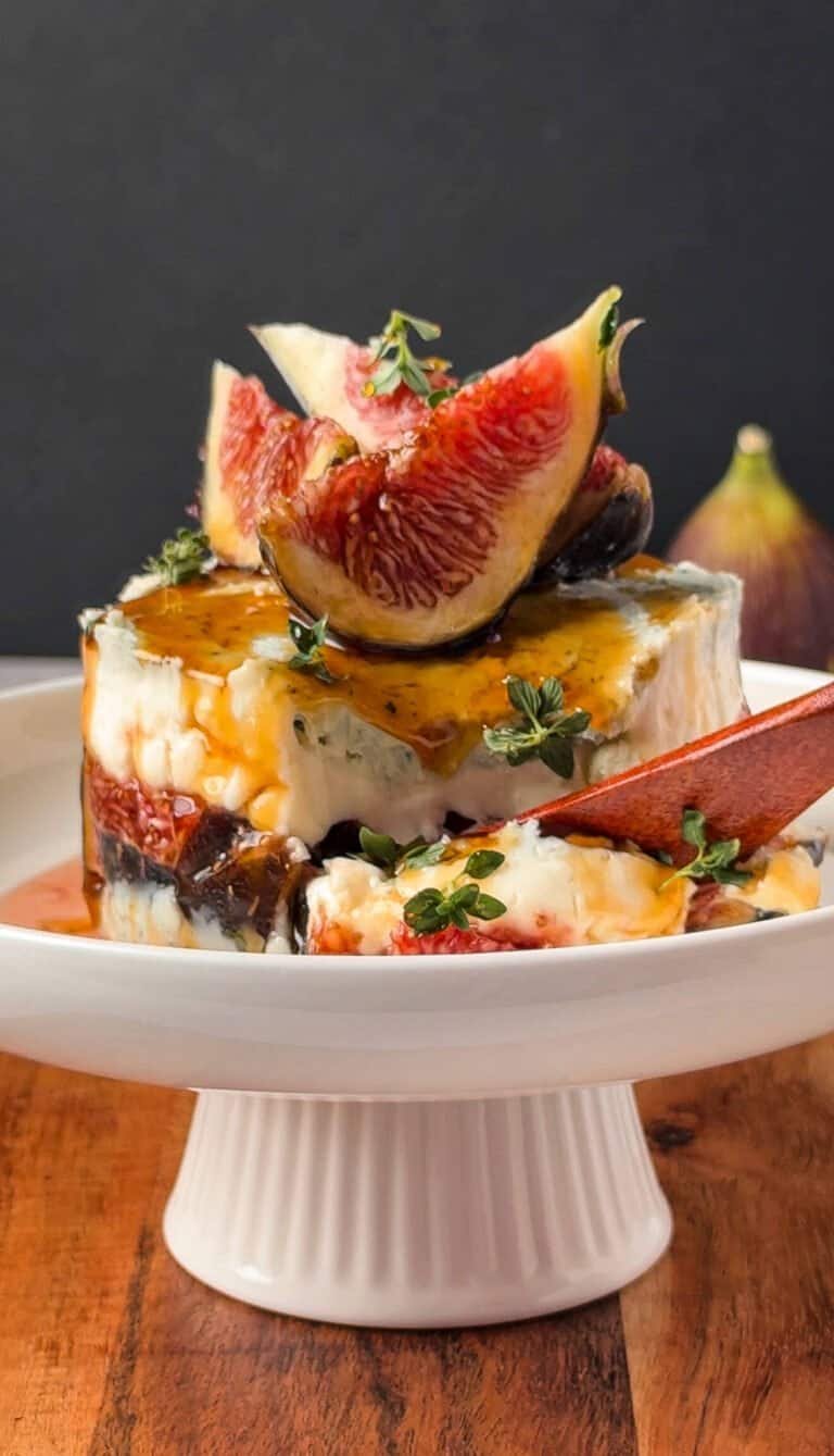 Cross-section of a gorgonzola fig and honey stack showing layered cheese and figs, served with a spoon