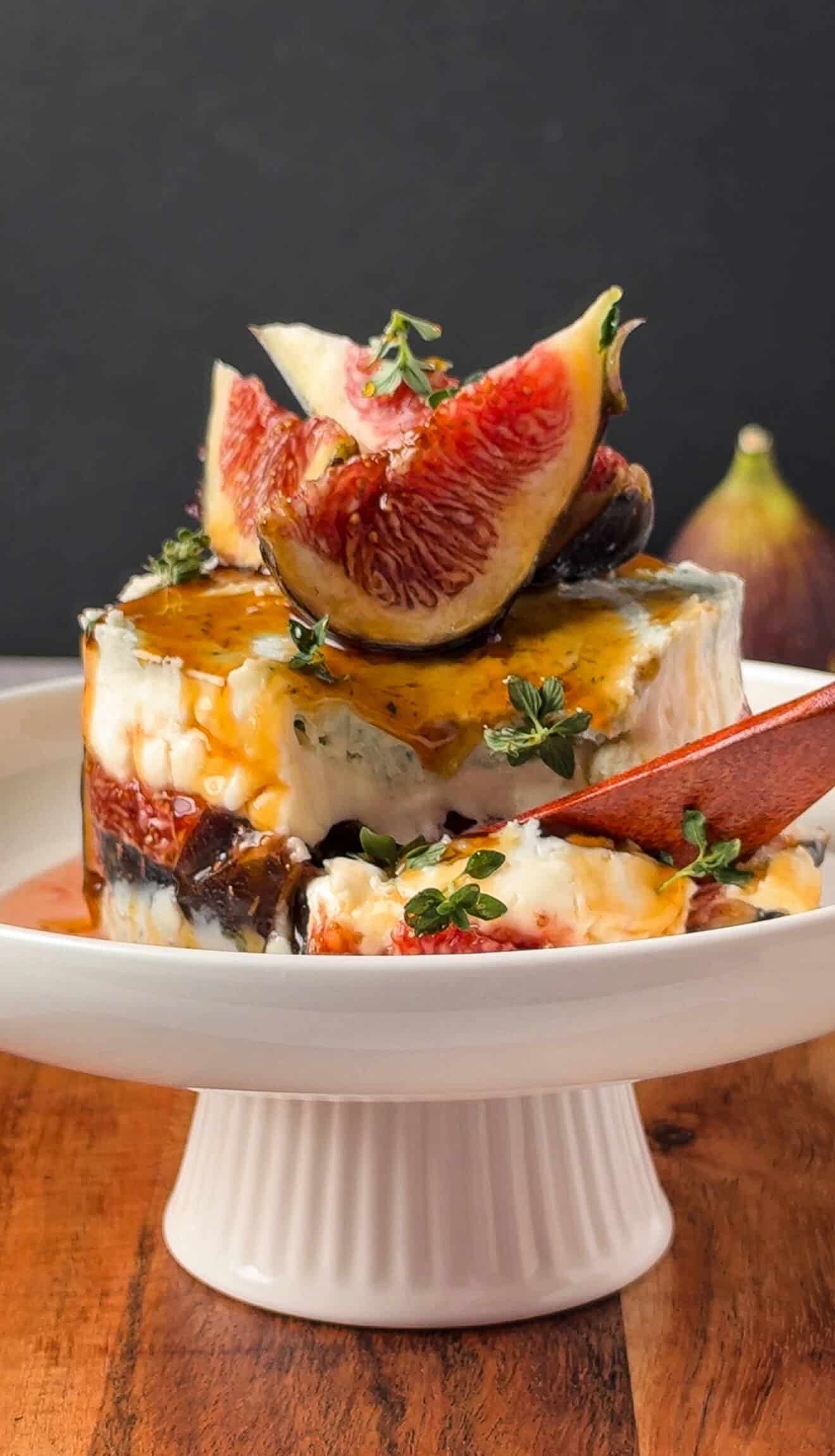 Cross-section of a gorgonzola fig and honey stack showing layered cheese and figs, served with a spoon