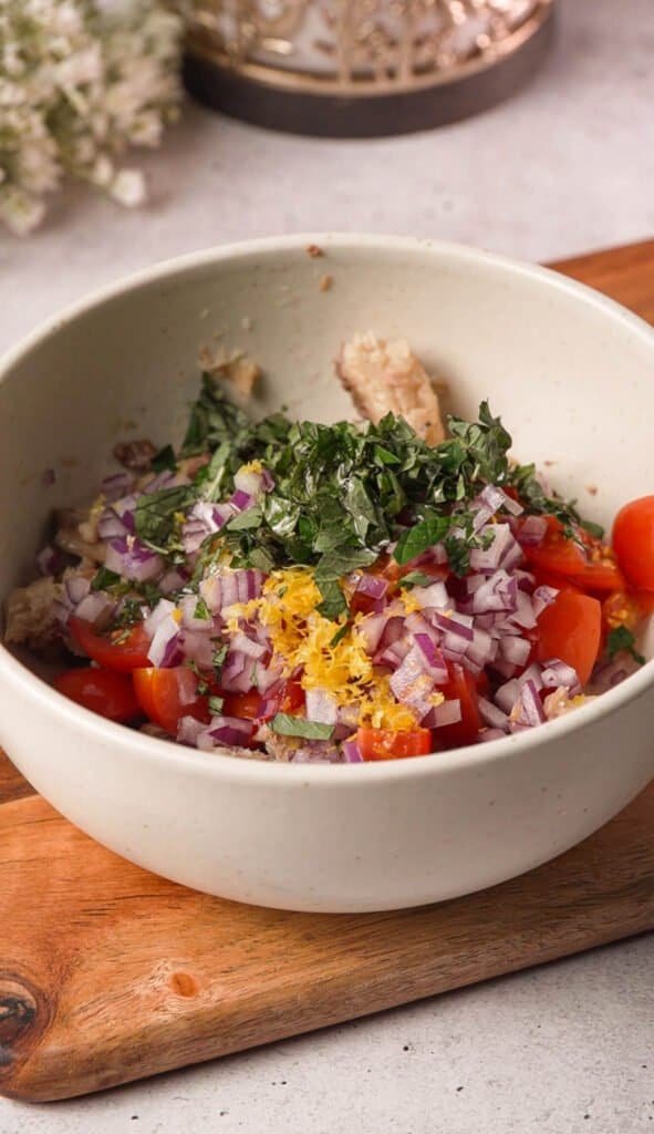 Sardine toast topping with cherry tomatoes, red onion, basil, and lemon zest