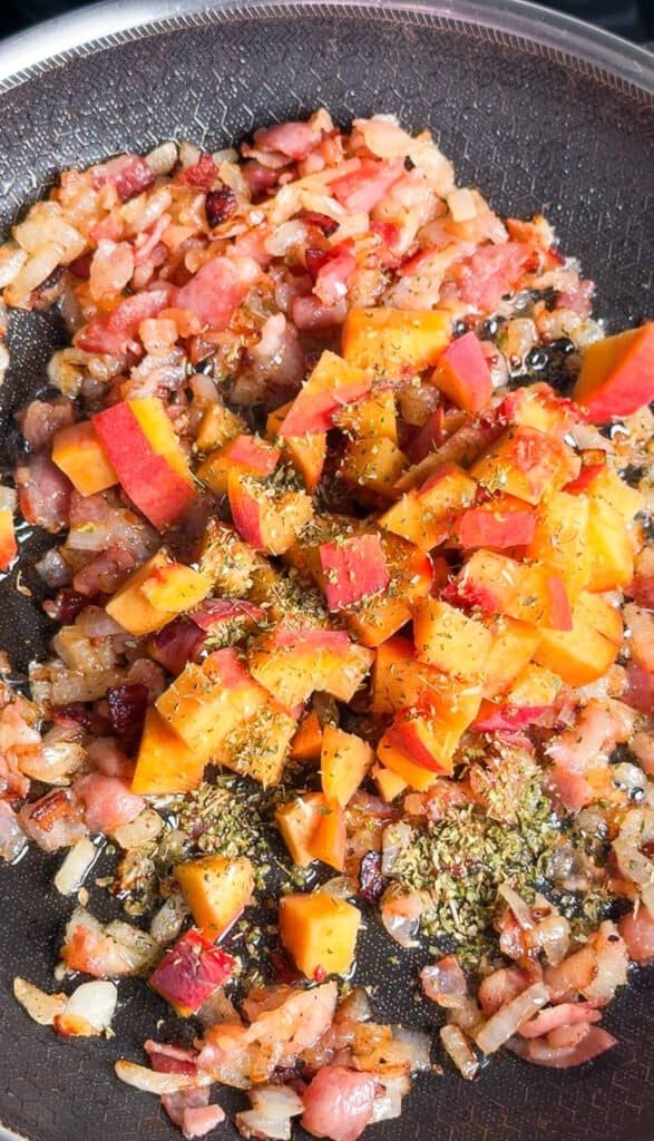 Caramelized Vidalia onion, bacon, and peach cooking together in a skillet