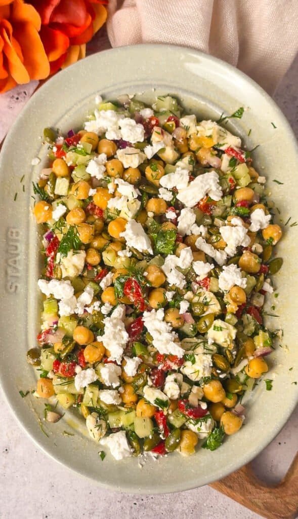 overhead view of Mediterranean chickpea salad with feta, roasted red pepper, cucumber, and pepitas