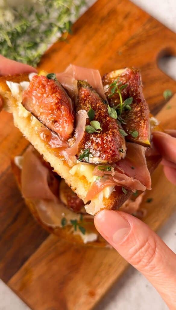 Cross-section of roasted fig and brie toast showing melted cheese and prosciutto layers