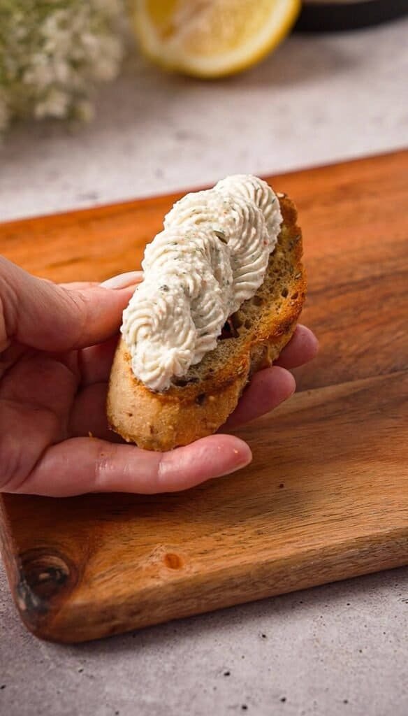 Toasted crostini topped with piped whipped crab cream cheese before adding shrimp