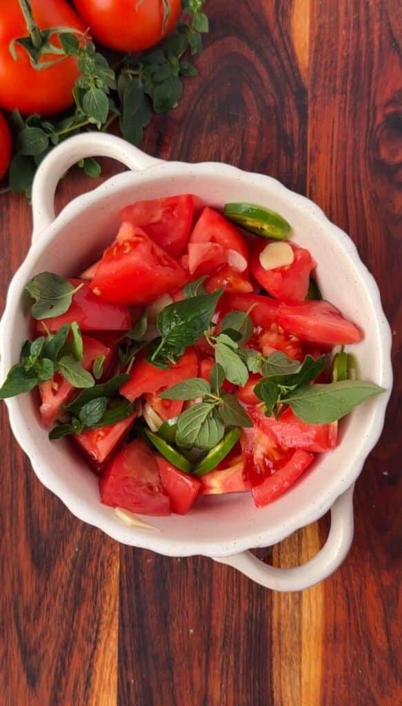 Chopped tomatoes, sliced jalapeno, garlic and oregano in a baking dish before adding feta