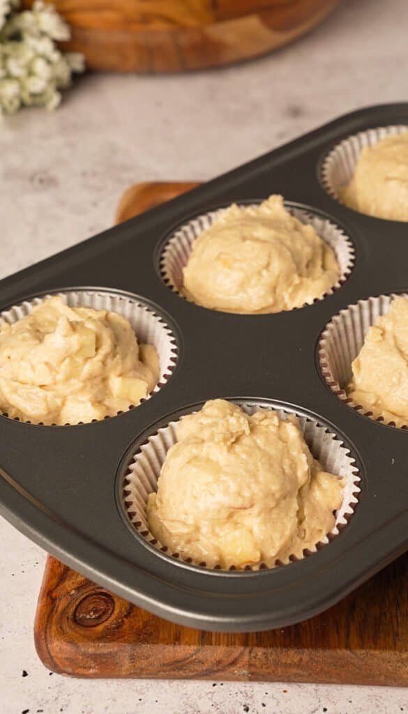 Apple cupcake batter portioned into a lined muffin tin before baking
